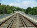 Trať na mostě přes Hlubočepskou ulici pokračuje v klesání otevřeným kolejovým svrškem v přímém úseku