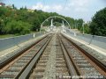Trať na mostě přes Hlubočepskou ulici pokračuje v klesání otevřeným kolejovým svrškem v přímém úseku