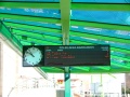 Digitální informační panel s oboustrannými ručičkovými hodinami zobrazuje časy nejbližších odjezdů linek ze zastávky Poliklinika Barrandov | 7.2.2004