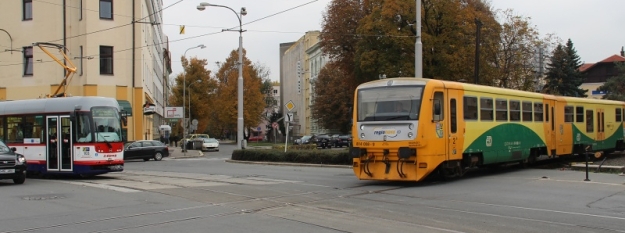 Důvod je zřejmý ihned. Přes úrovňový železniční přejezd překonává vozovku a tramvajovou trať obsazený jednotkou Regionova. | 14.10.2013