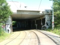 Tramvajová trať i po opuštění podjezdu pokračuje v levém oblouku a postupně se napřimuje mezi náspy Jižní spojky a železniční tratě.