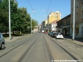 Přímý úsek tramvajové tratě ve staré zástavbě Nuselské ulice, tramvaje se zde doslova prodírají mezi parkujícími automobily.