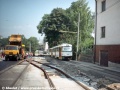 Souprava T3m ev.č.61+62 směřuje od zastávky U Pekáren k Vápence, zatímco ve středu ulice finišuje výstavba dočasné výhybny na nové trati. | 18.8.1998