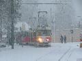 Zcela zasněžená souprava vozů T3SUCS ev.č.7075+7048 vypravená na linku 23 projíždí za vydatné sněhové vánice obloukem mezi protisměrnými zastávkami Pražský Hrad | 23.1.2005